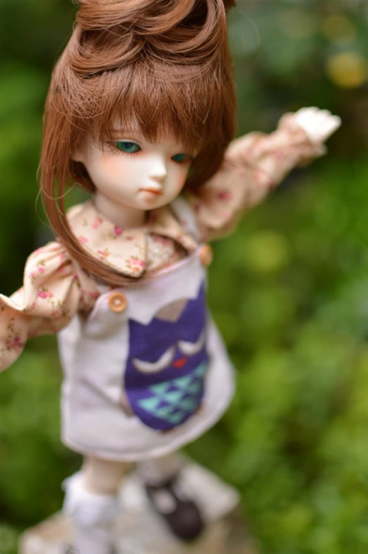 an doll doll in a dress with her arms stretched out