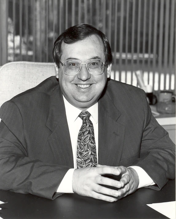 a close up of a person wearing glasses and a suit