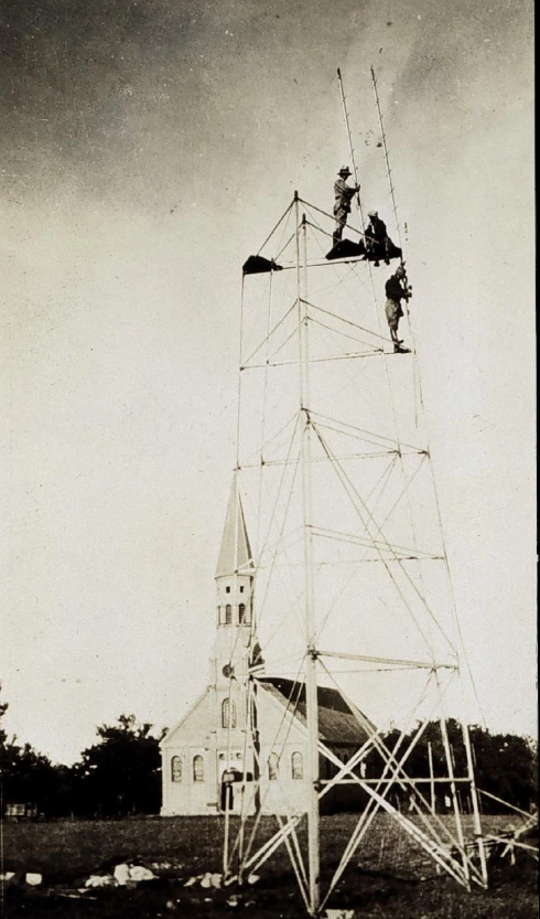 a man on a large tower climbing to the top of it