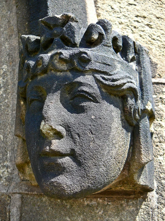 a stone head is displayed next to a stone building