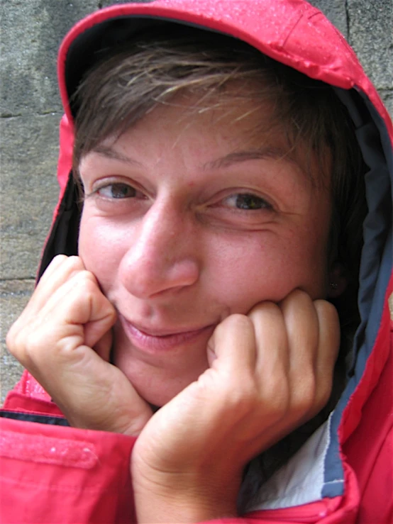 a person with a red jacket and a grey background