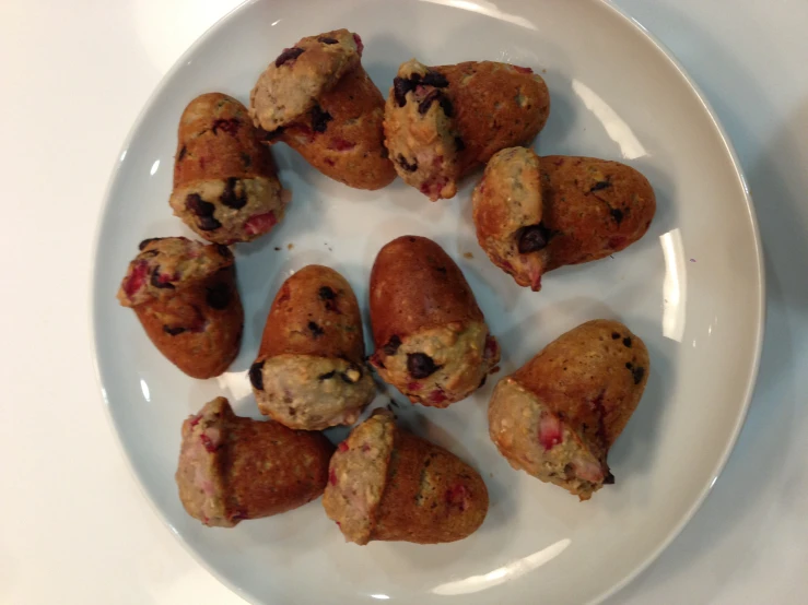 a white plate topped with a muffin filled with berries