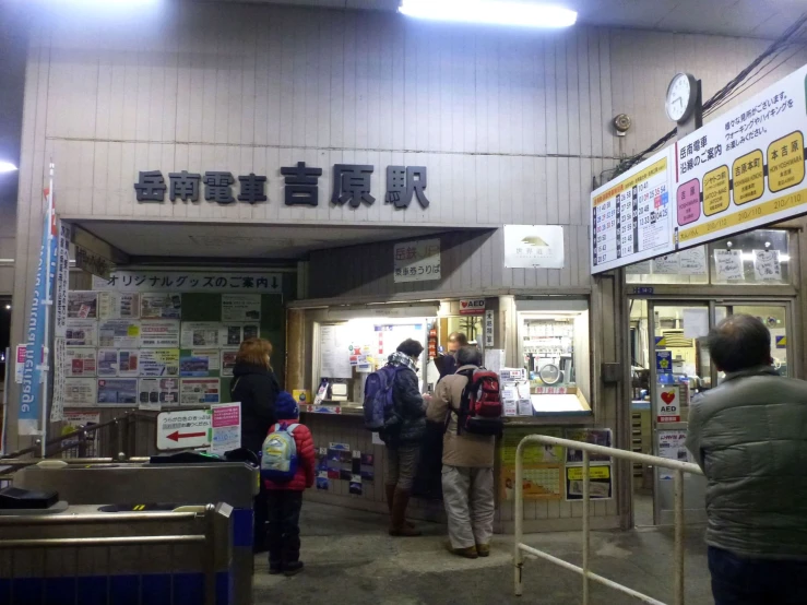 several people are outside of a building with information in the door