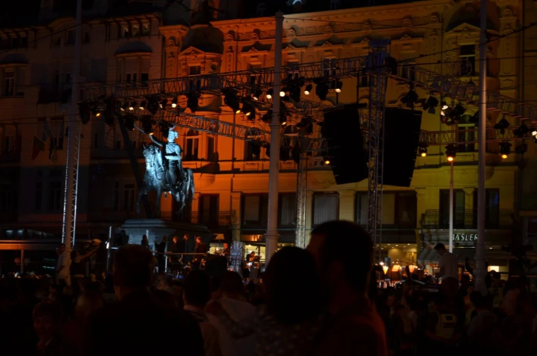 crowd watching a lit up statue at night