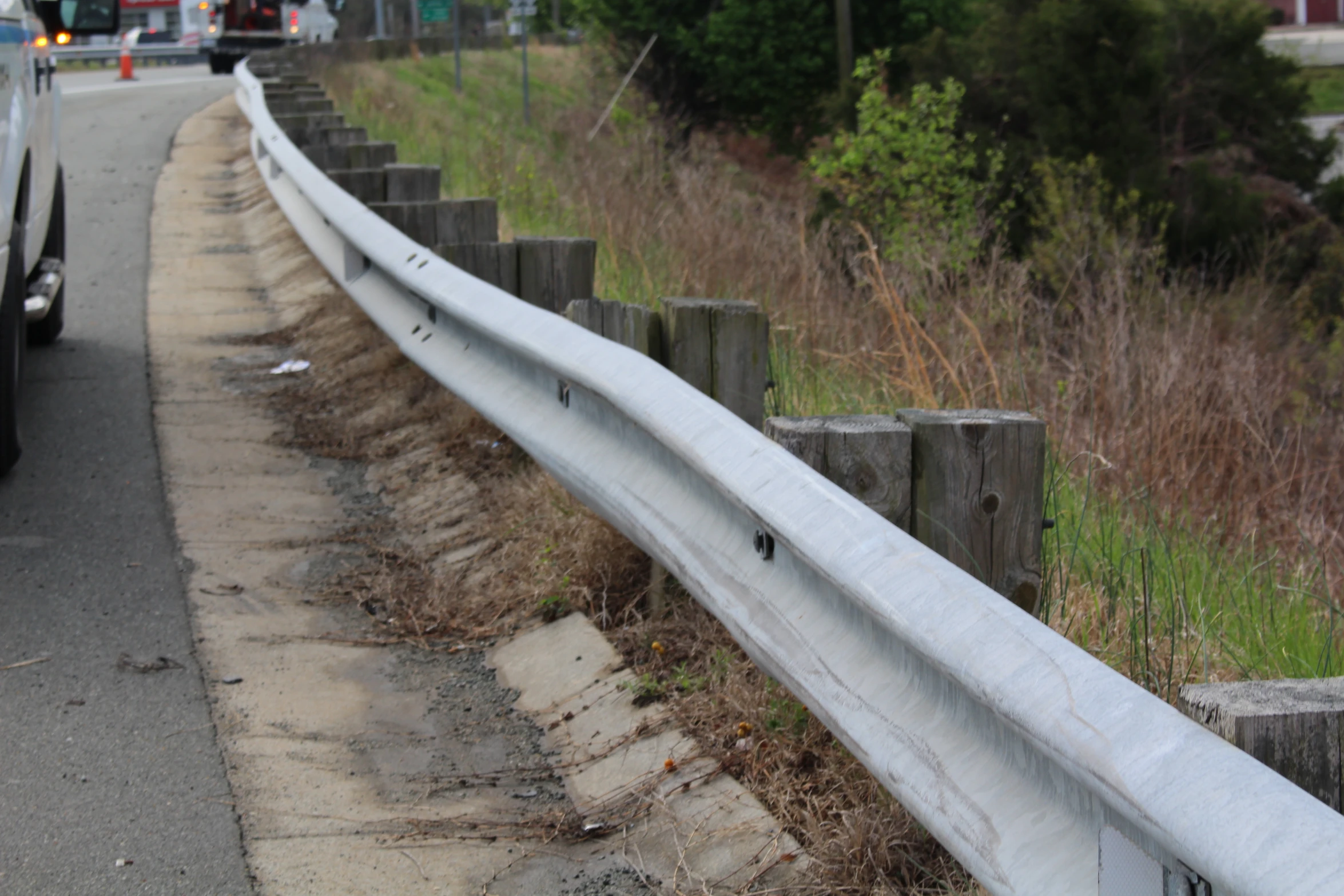 a guardrail by the side of the road with vehicles