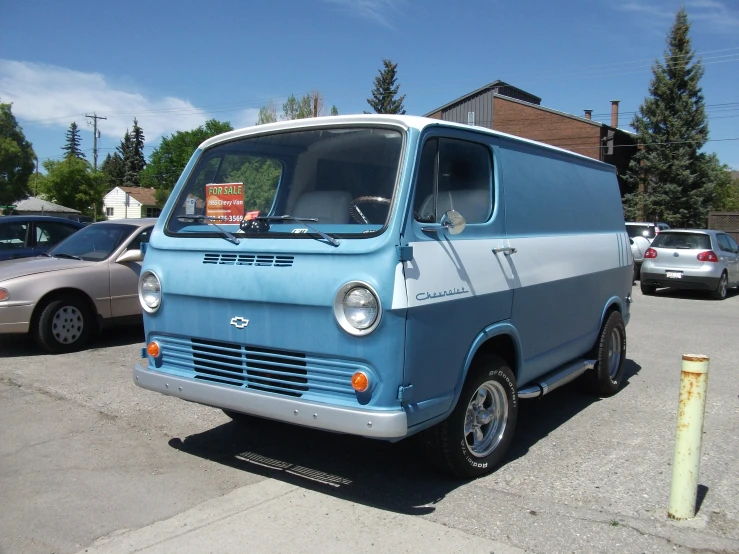 an old van sits in the parking lot next to several parked cars