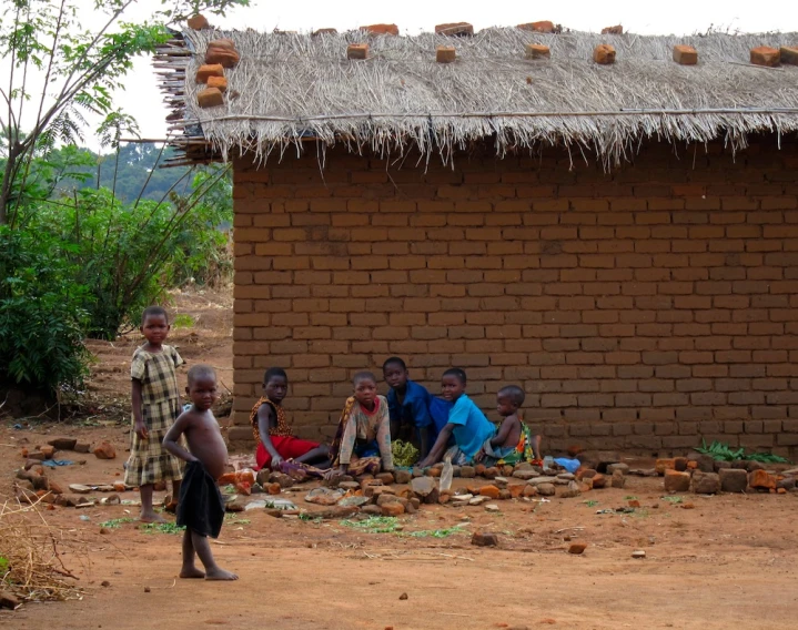 a group of people sitting outside near a brick building