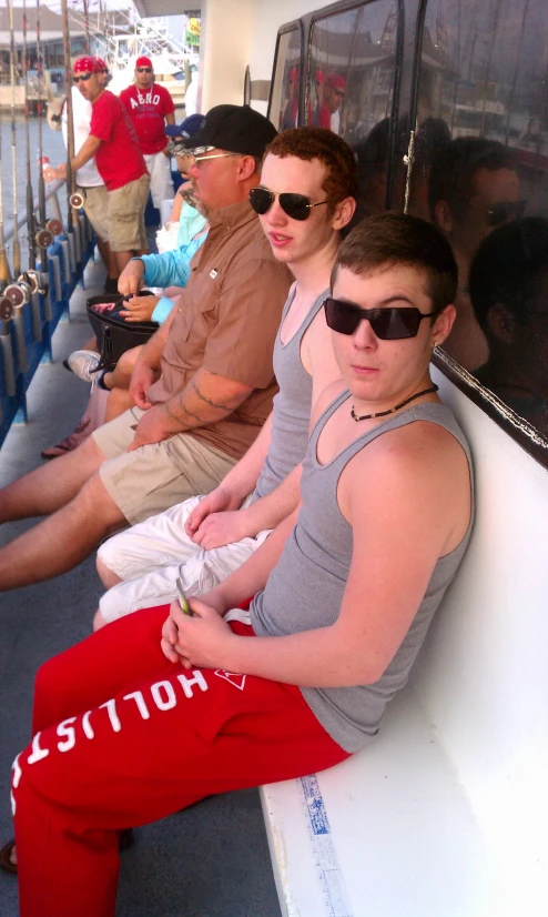 a group of young men wearing shades sitting in a row