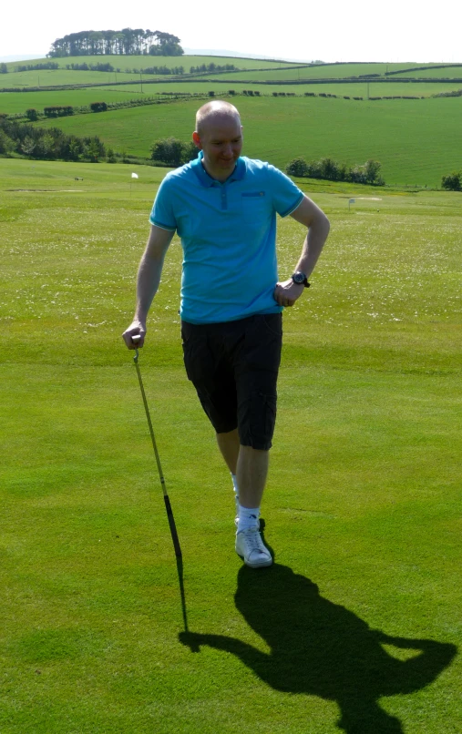 a man on a green grass covered golf course