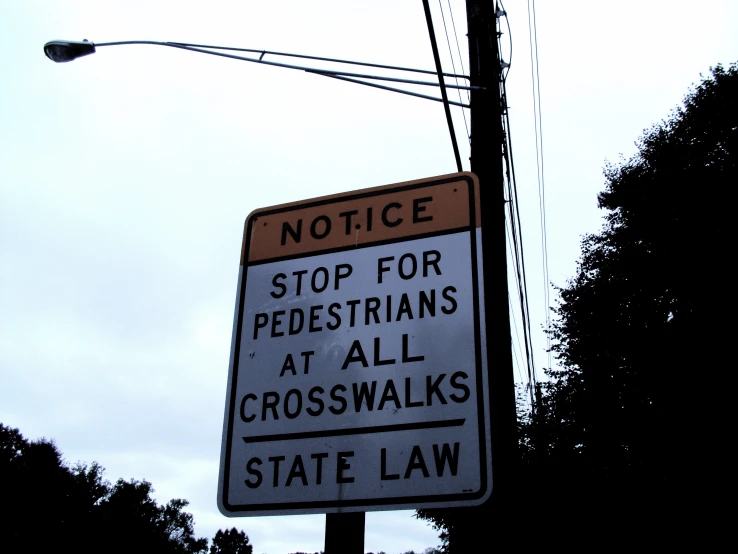 a sign warns of a stop for pedestrians at crosswalks