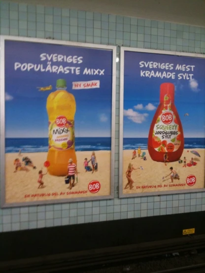 two advertising boards are attached to the wall near a subway