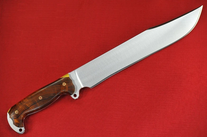 a knife with a wood handle sitting on top of a red cloth