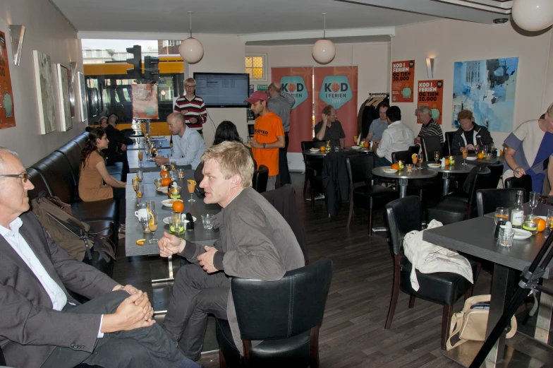 people gathered around tables in a small room