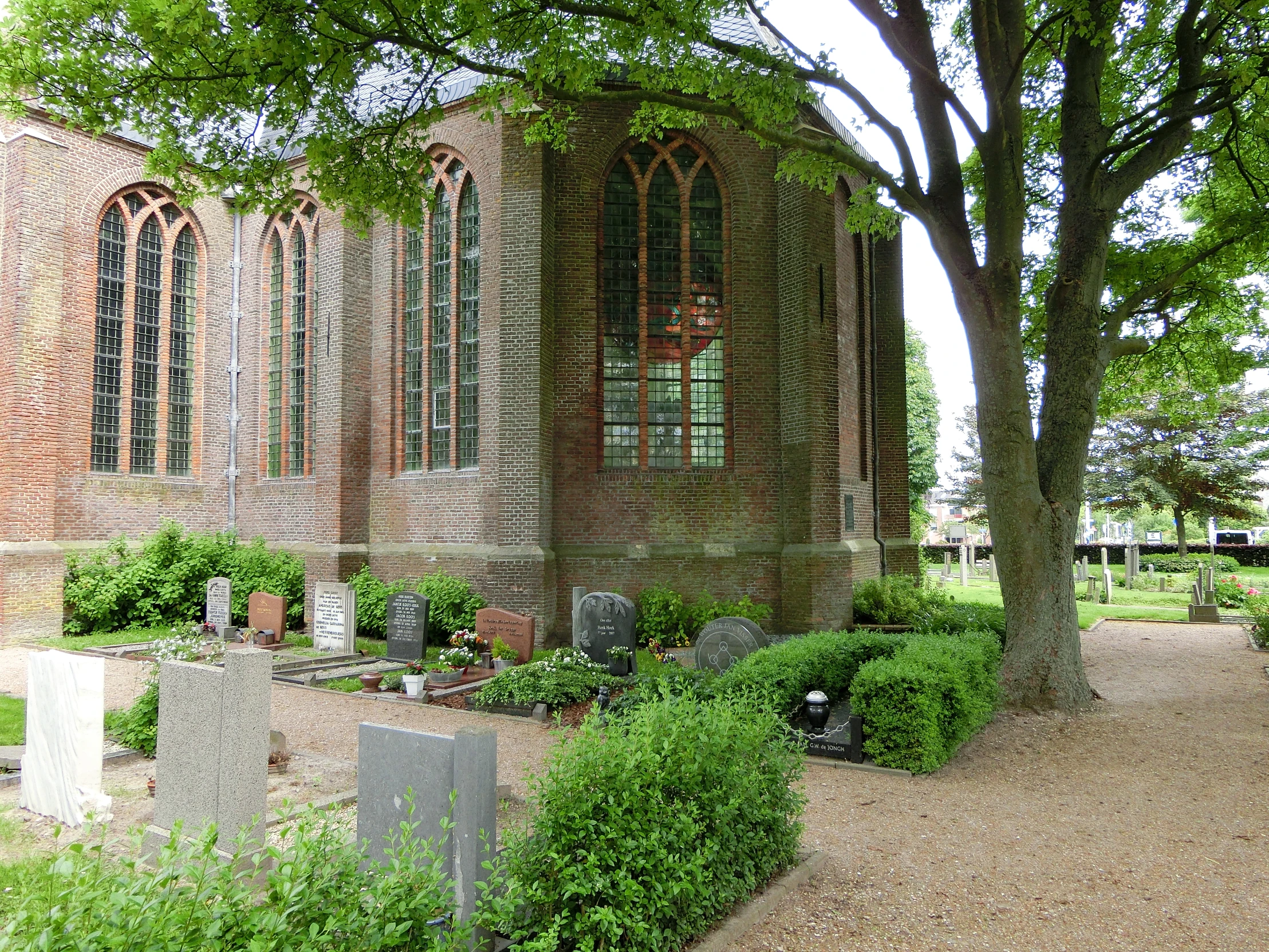 a red brick building surrounded by trees and plants