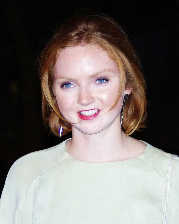 a close - up of a woman with short blonde hair, blue eyes and bright red lips