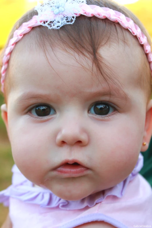 an adorable young baby girl with a head band