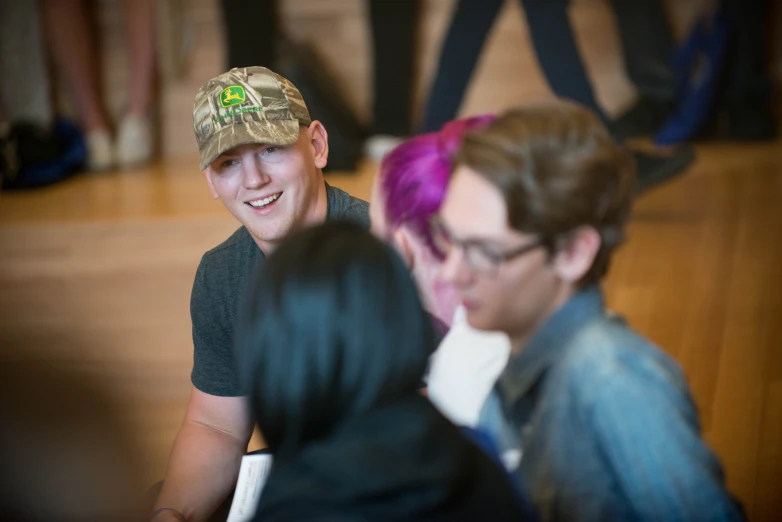 a woman with purple hair is sitting with a smiling boy