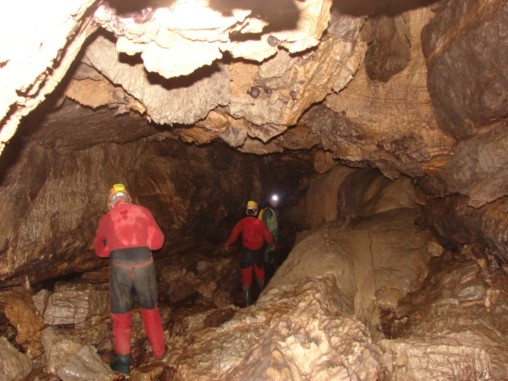 two men in red jackets in a cave