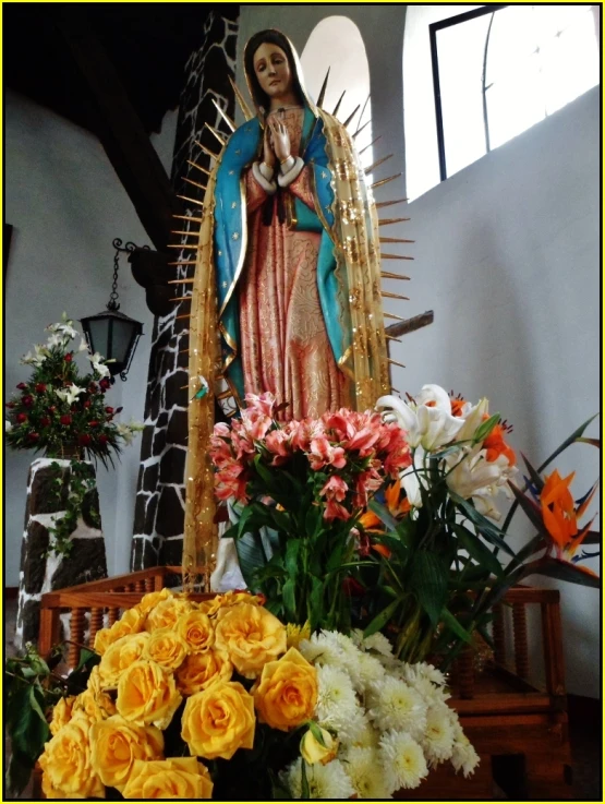 statue in a church with yellow flowers inside