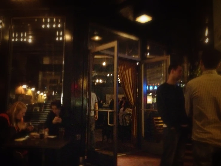 group of people sitting outside an outside restaurant at night