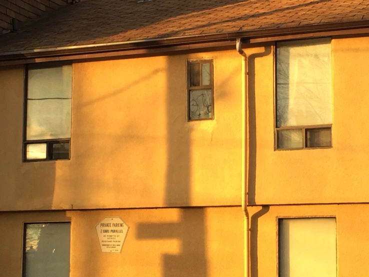 a very tall yellow apartment building with a street light