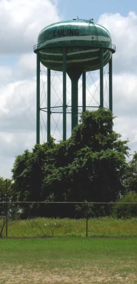 the large water tower is located beside the trees