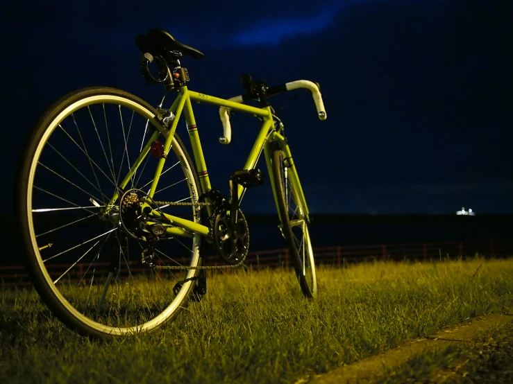 a bike in the dark is sitting on a grassy field