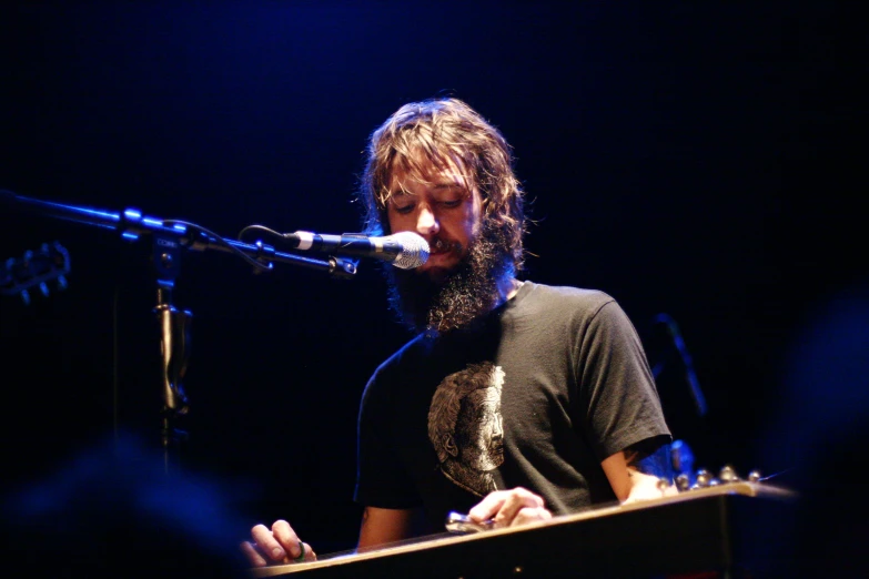 a man with long hair on top of a microphone