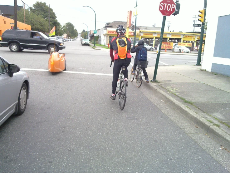 two people are riding their bikes down the road