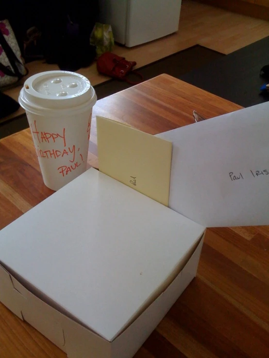 a cup and two boxes sit on a wooden surface