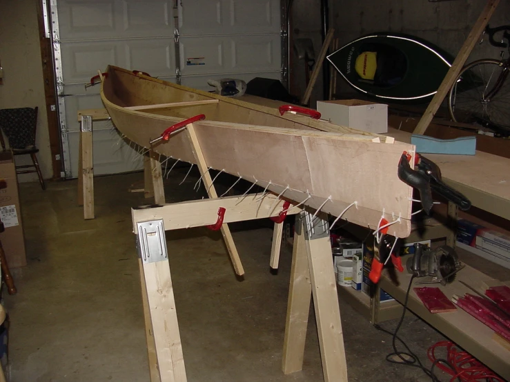 a wooden boat on top of wooden planks with rope