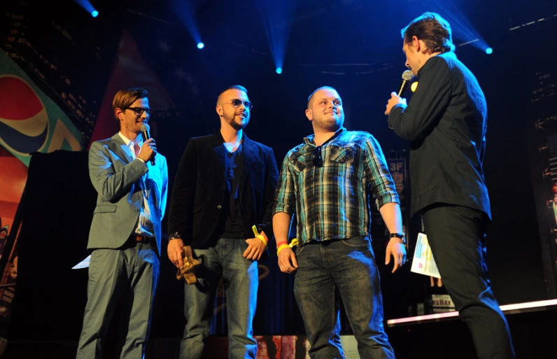 men with ties talking on stage at night