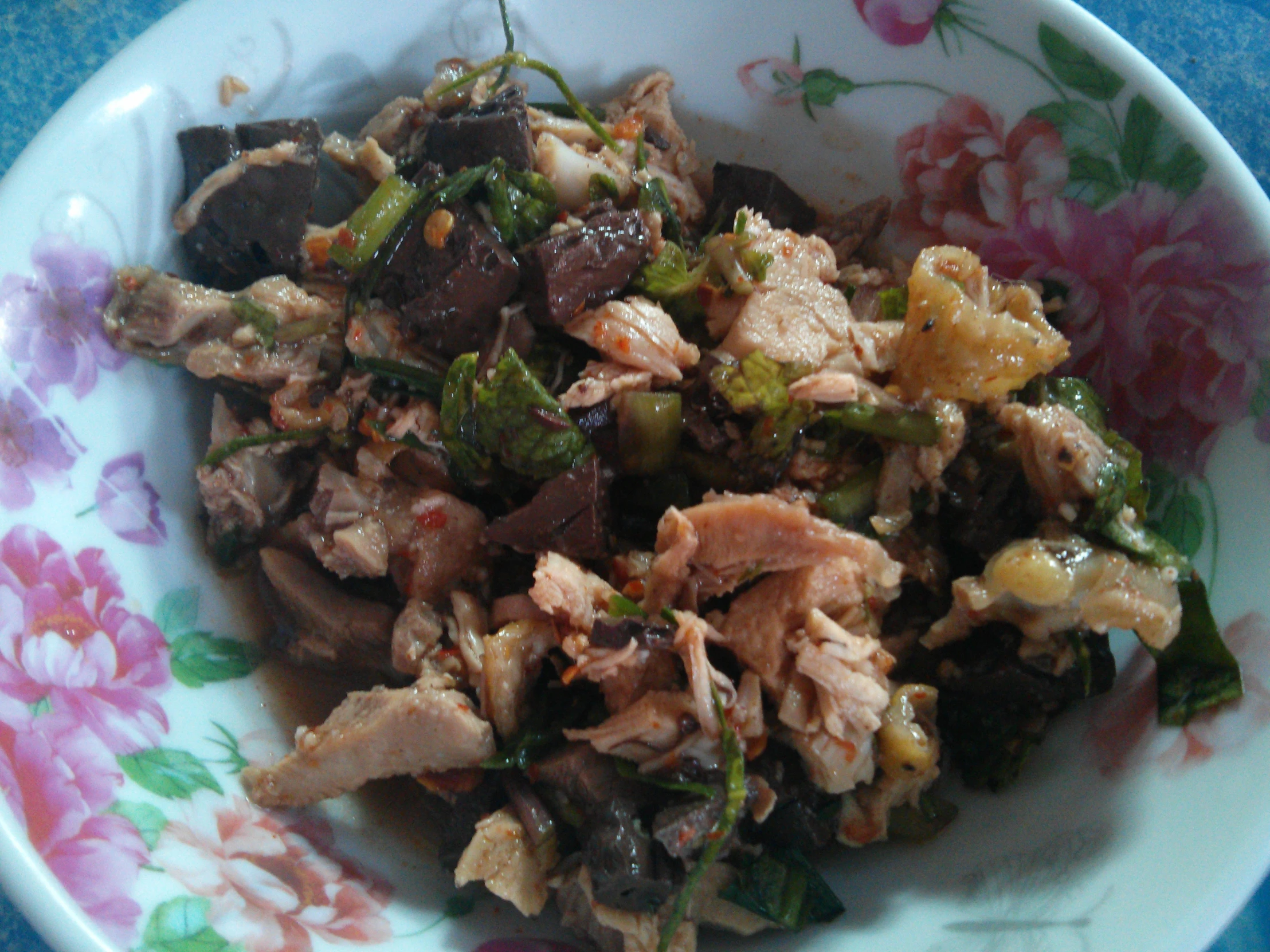 a white plate with colorful flower designs holds a bunch of food