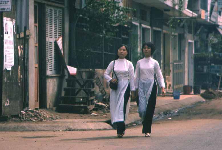 two girls walking down the street with their bags