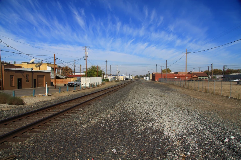 an empty railroad tracks with buildings on either side