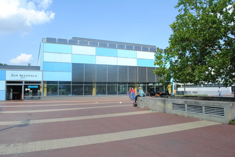 a building with people sitting around it near trees