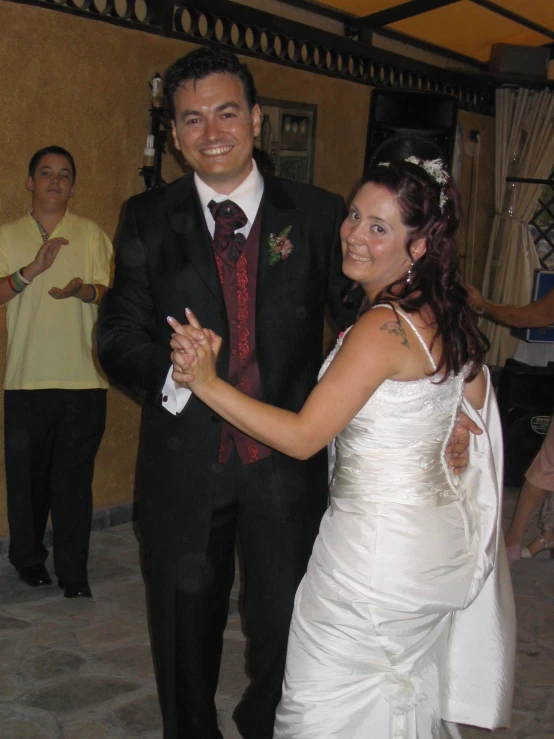 a man in a tux and a woman in a white wedding dress dancing