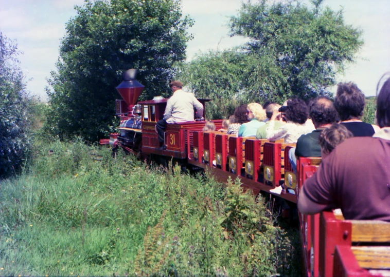 people sitting in the back of a red train
