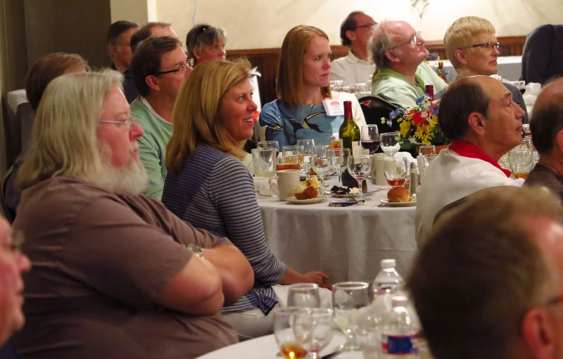 a group of people sitting at round tables having conversation