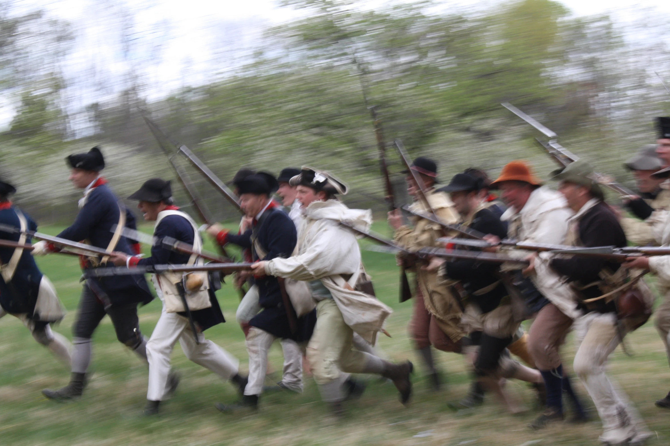 a bunch of men running in a line with guns