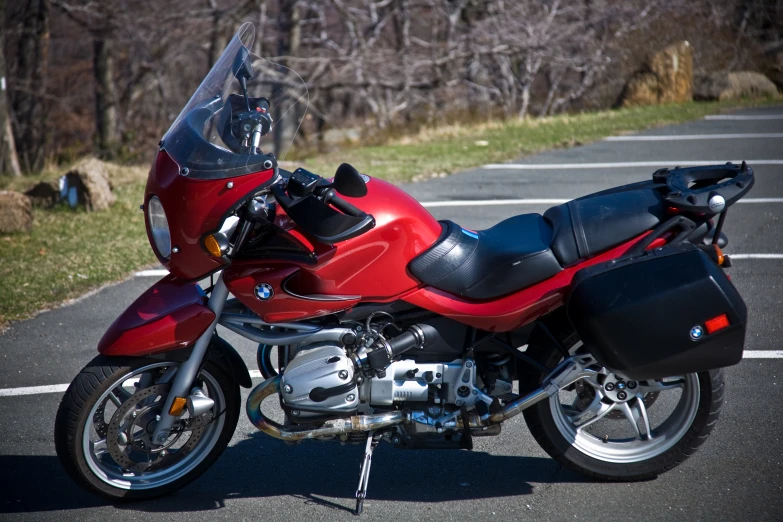 a red and black motorcycle parked on asphalt in a parking lot