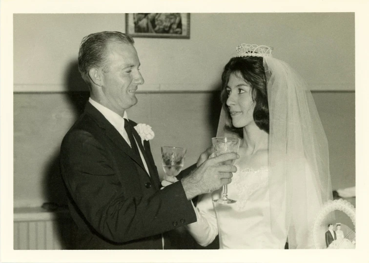 an old man and woman holding champagne glasses