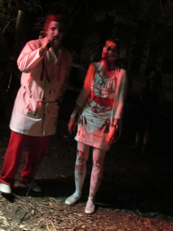 two people with costumes in the woods while one of them is wearing a zombie costume