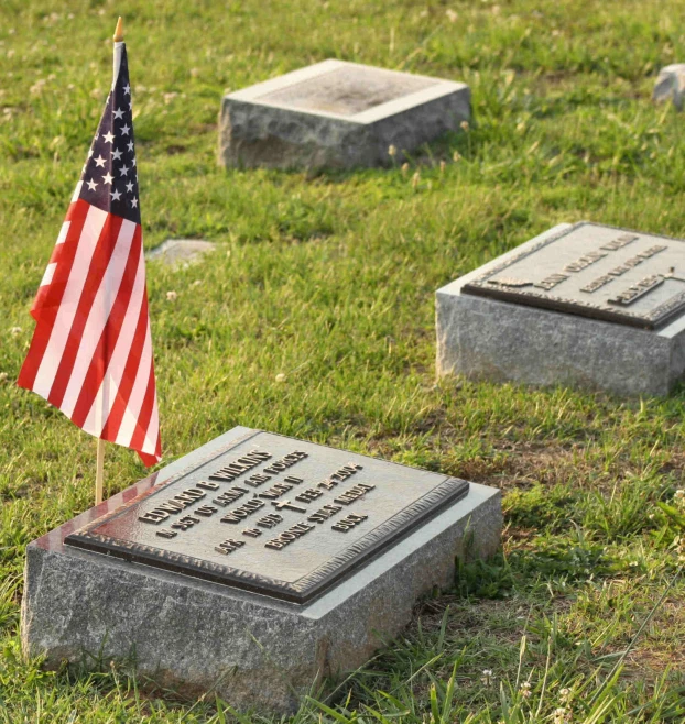 an american flag on a grave in a cemetery