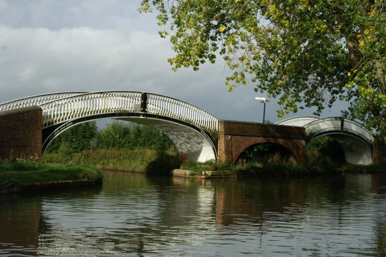 a bridge crossing over a lake with trees on either side