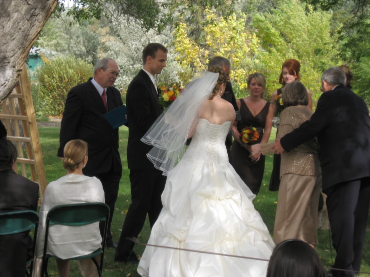 a bride and groom standing in the grass