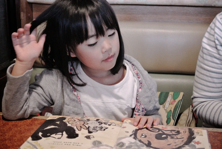 a little girl that is on the table with her hair