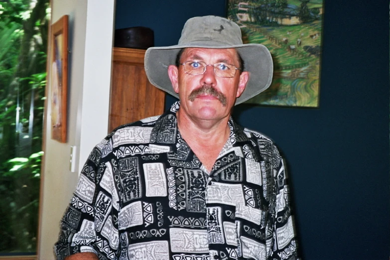 a man in a floppy hat sitting in a room