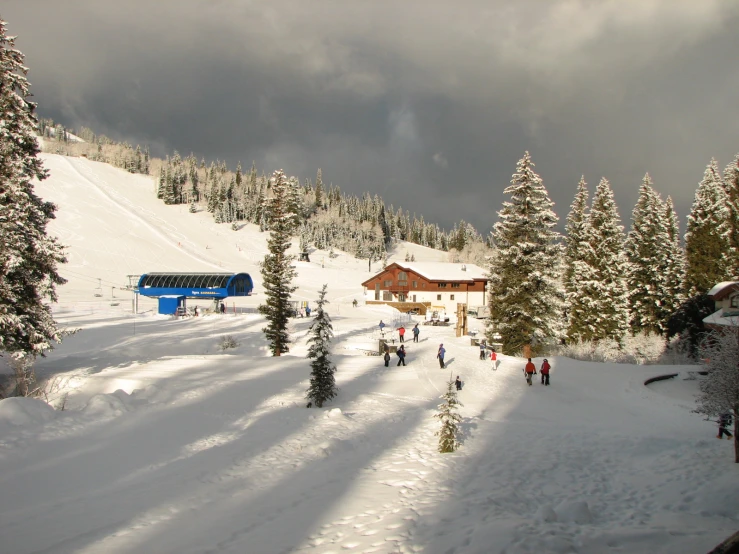 the skies are overcast, with people standing on the snow