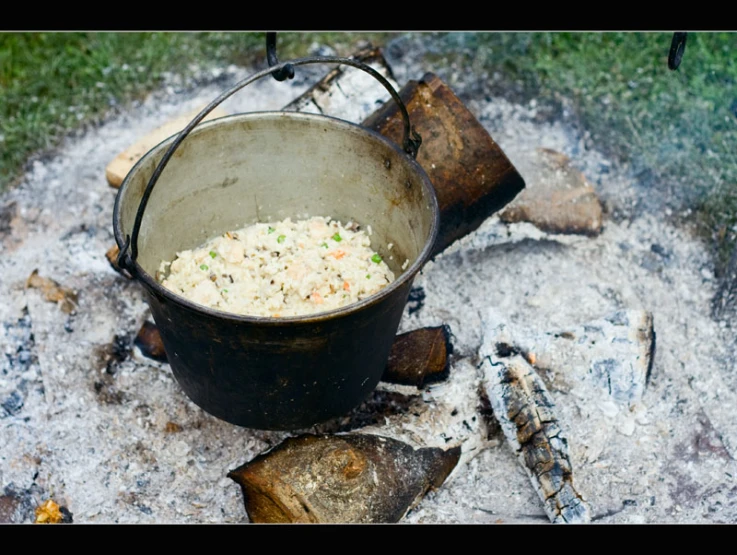 an outdoor cooking area with a stove and pot on fire